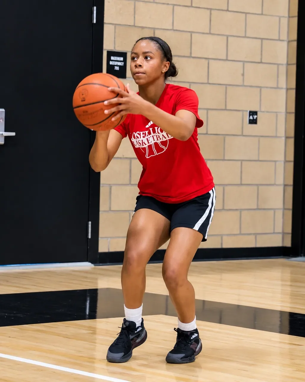 Jordynn Riggins setting up a shot with the basketball in a gym