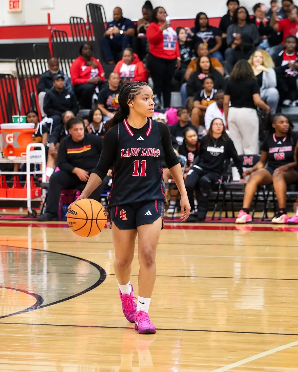 Jordynn Riggins carrying the ball during a focused basketball game moment